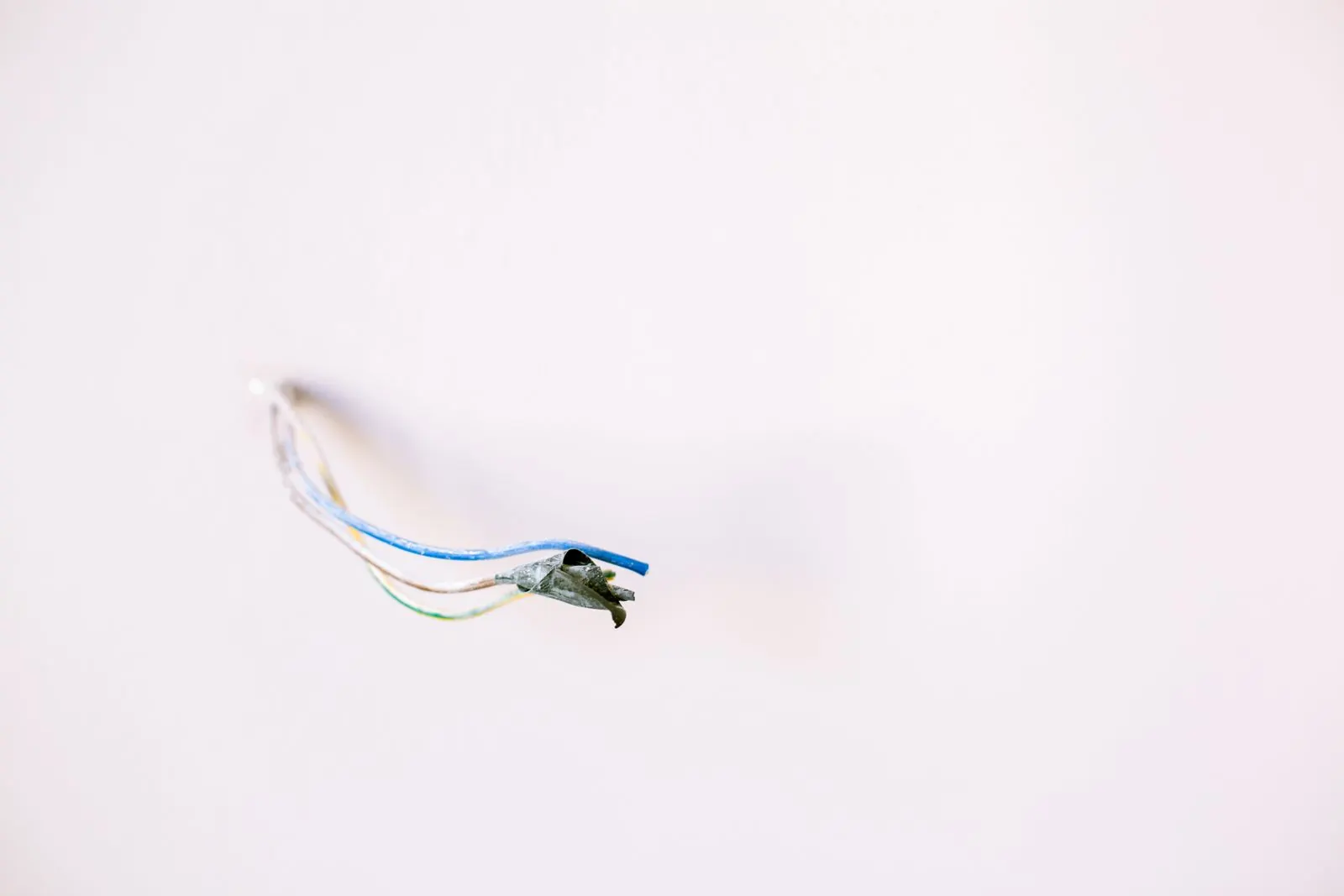 Technician testing thermostat wiring with a meter